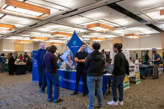 Students talking to a employer at a Career Fair at a table