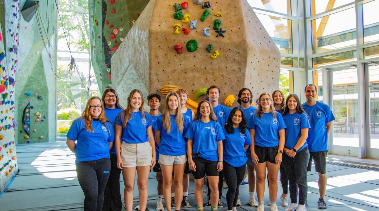 super kids camp staff standing in front of rock wall