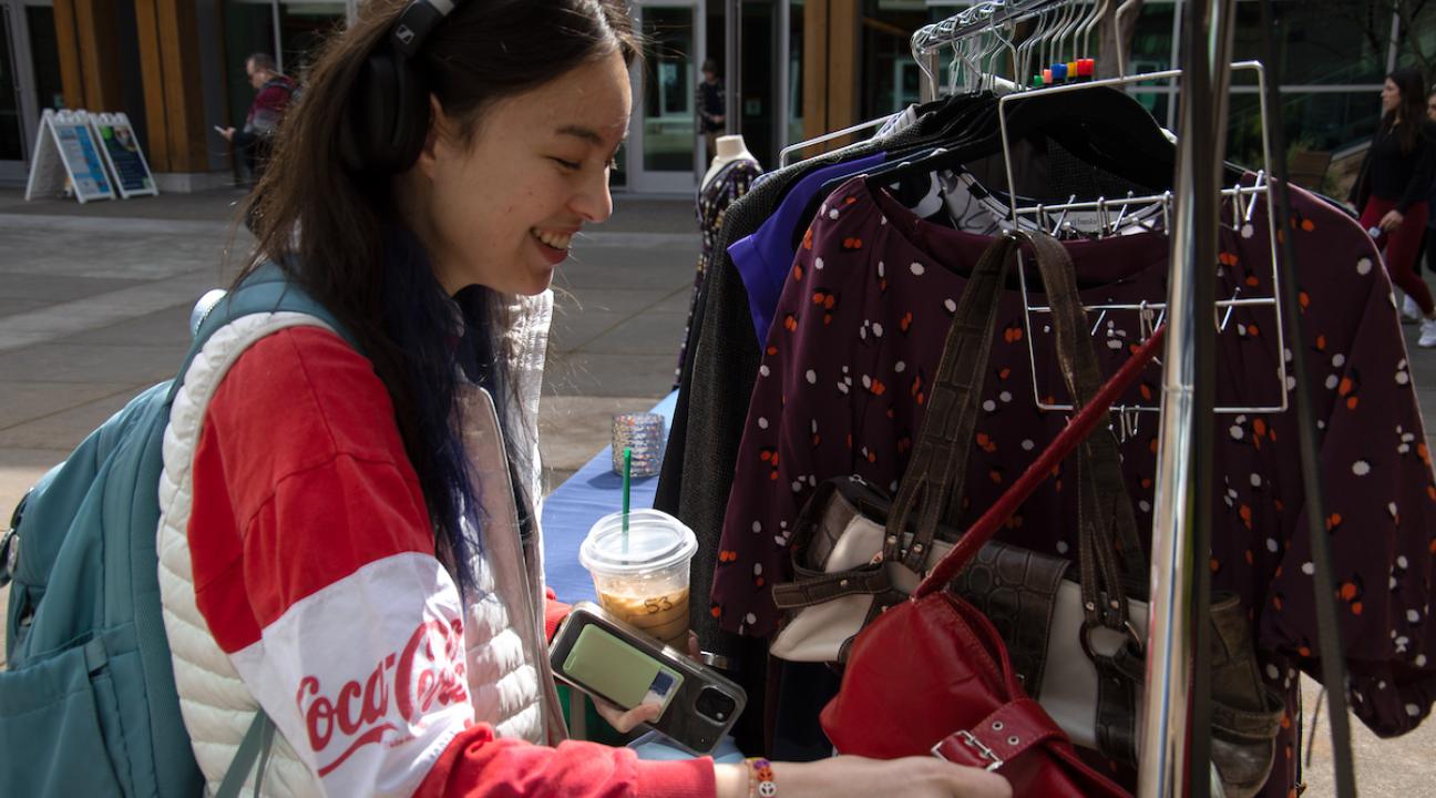 student looking through closes in career closet and smiling