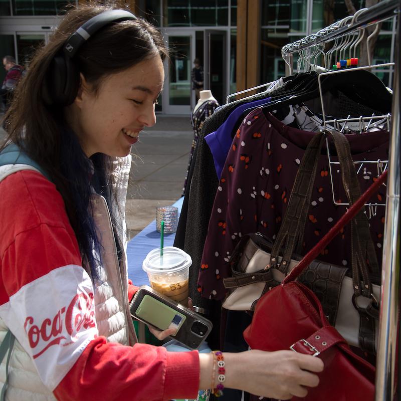 student looking through closes in career closet and smiling