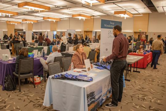 student speaking with potential employer at career fest table