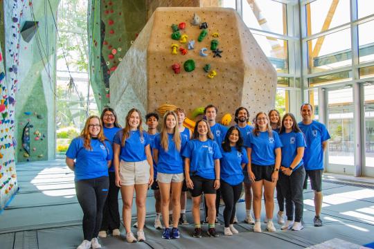 super kids camp staff standing in front of rock wall