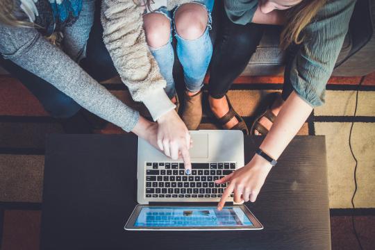 three students work collaboratively on a computer